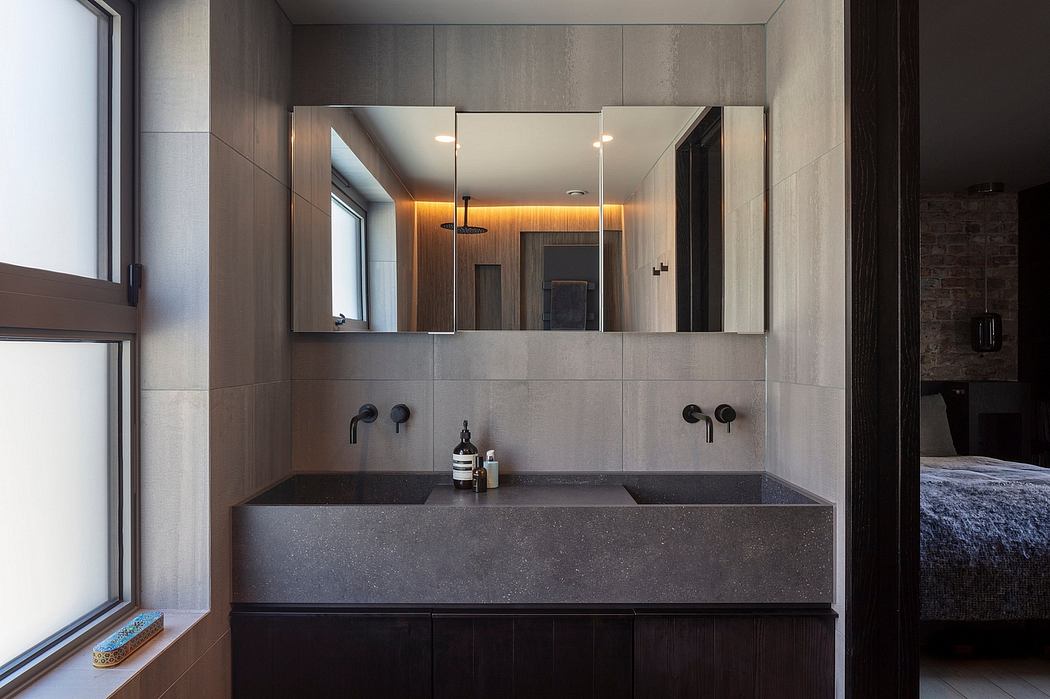 Sleek, modern bathroom with dark stone sink, recessed lighting, and mirrored vanity.