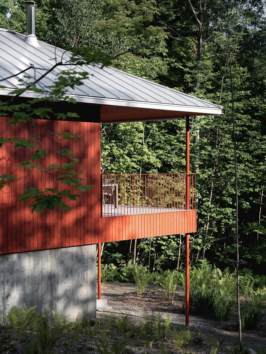 A cozy cabin nestled in a lush forest, with a metal roof and a wooden, partially glass-enclosed porch.