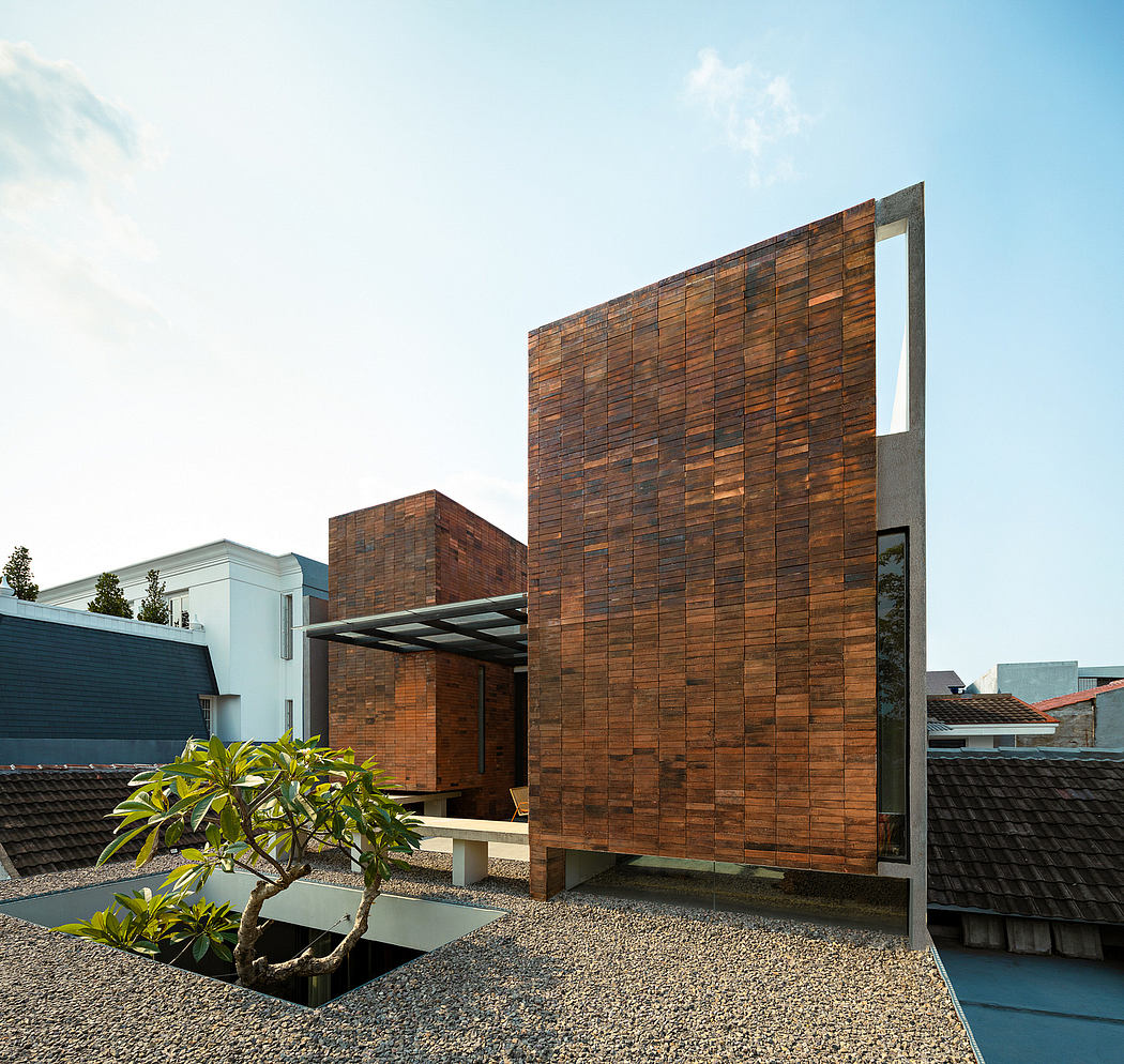 Modernist wooden facade with raised entryway and lush courtyard planting.