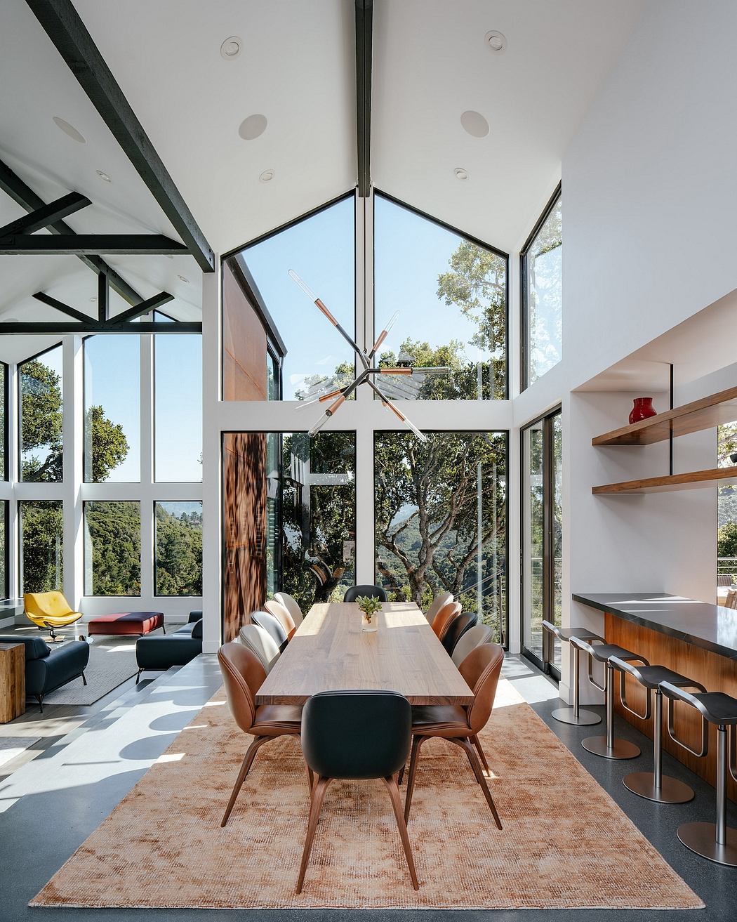 Spacious modern living area with sleek furniture, floor-to-ceiling windows, and a striking lighting fixture.