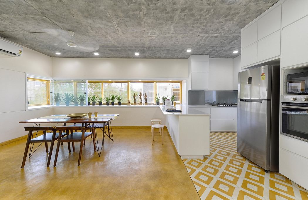 Spacious, modern kitchen and dining area with concrete ceiling, geometric tile flooring.