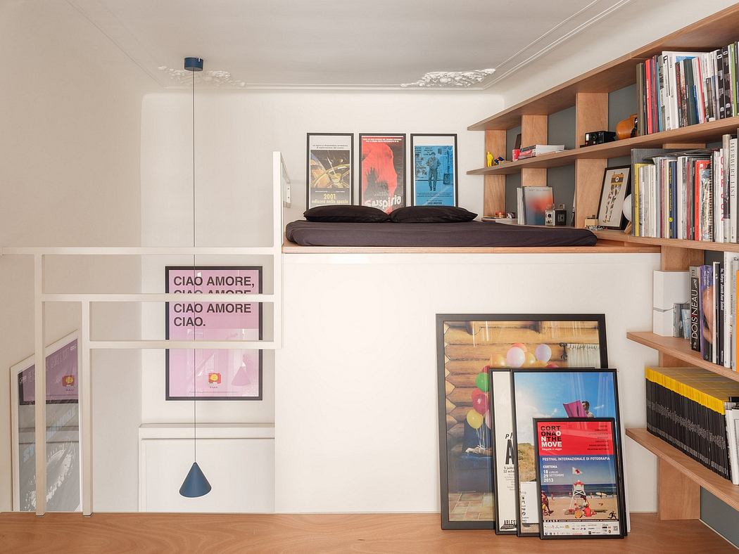 A cozy bedroom with built-in shelves, framed posters, and a hanging lamp creating a warm, inviting atmosphere.