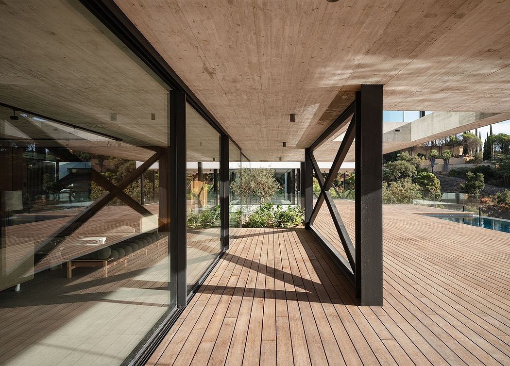 A contemporary architectural design featuring a covered wooden deck, glass walls, and geometric support structures.