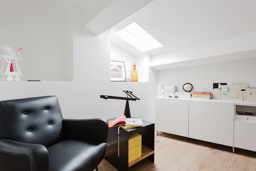 Bright, minimalist home office space with sleek black leather armchair and shelving.