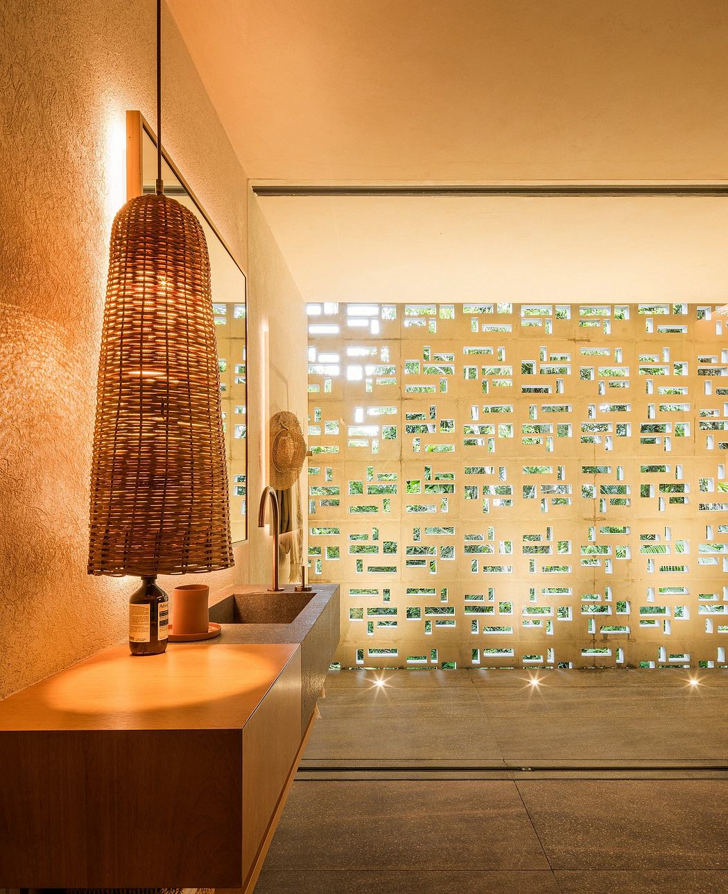 A cozy room with a woven rattan light fixture, wooden bench, and patterned tile wall.