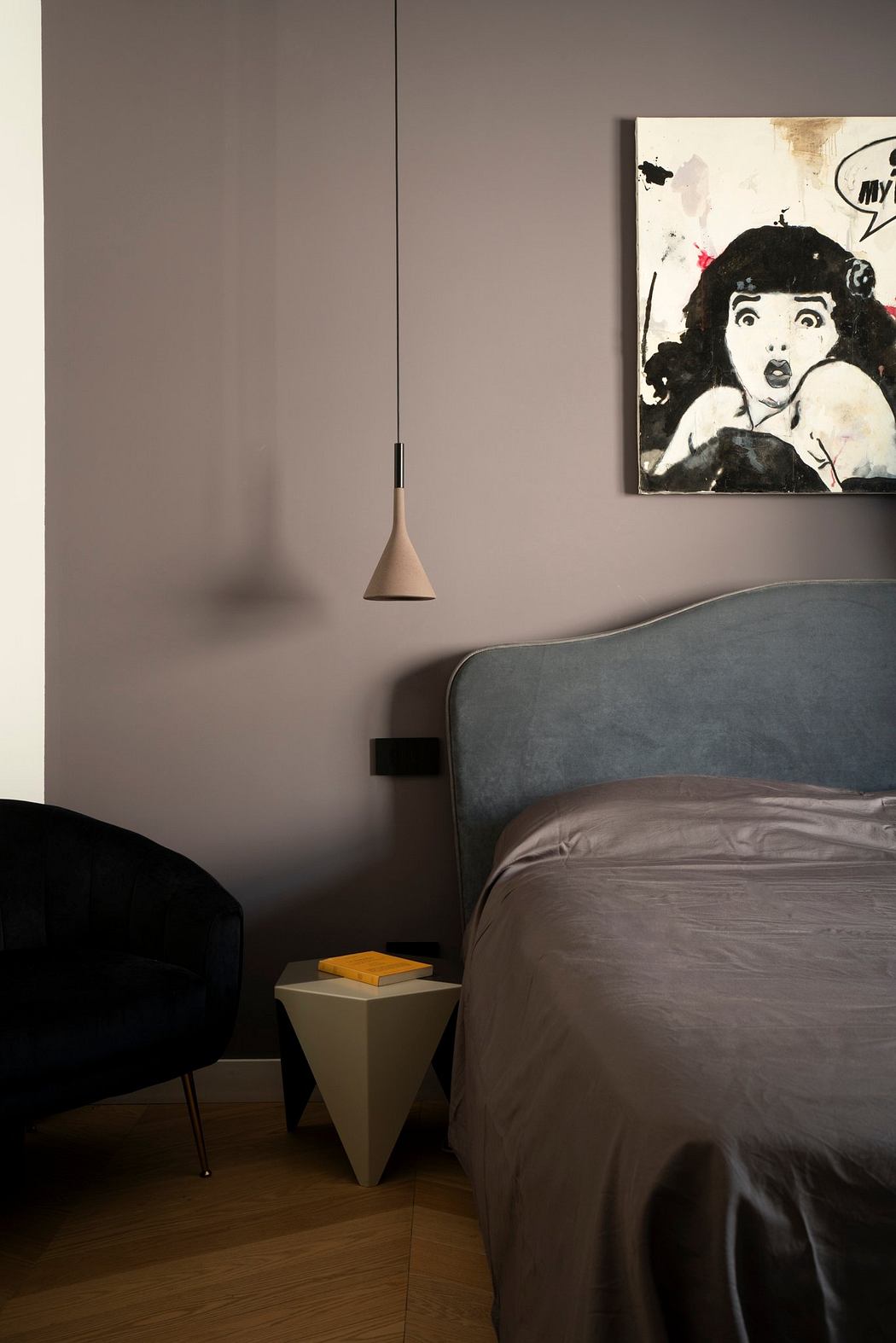 Modern bedroom with minimal decor, geometric pendant light, and expressive wall art.