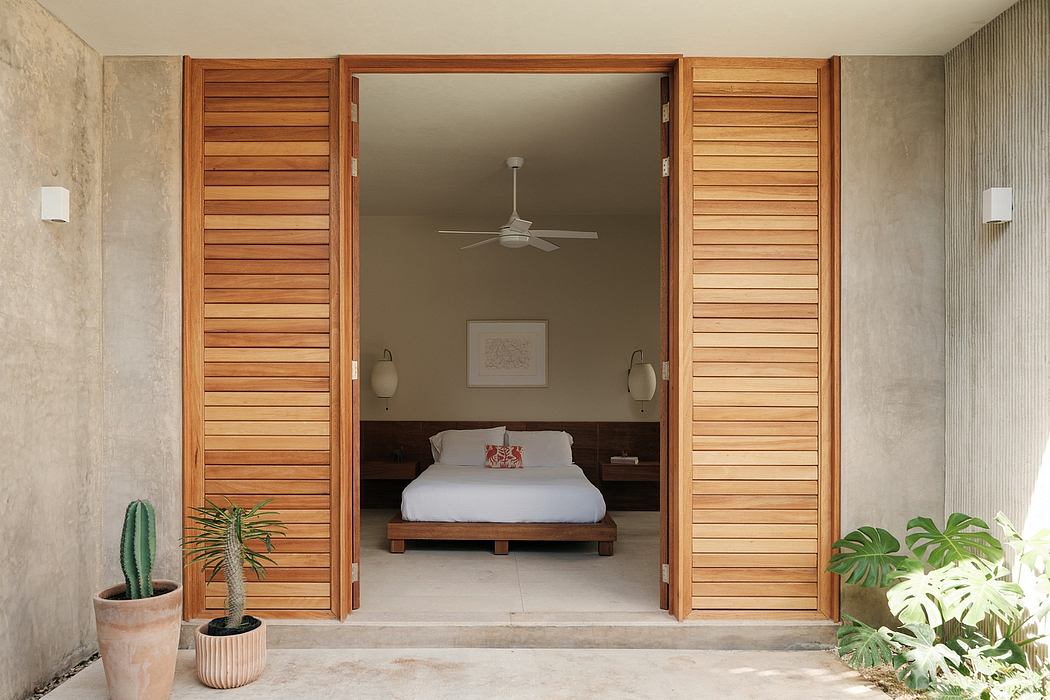 Spacious, minimalist bedroom with wooden slatted doors, neutral palette, and indoor plants.