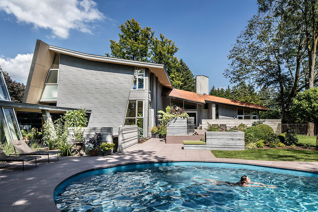 Sleek, modernist home with curved roofline, large windows, and an inviting pool.