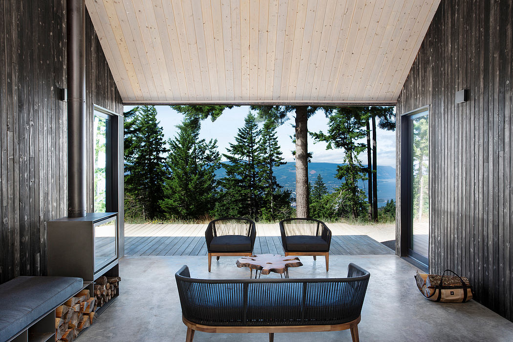 Rustic wooden cabin with modern furniture, expansive deck, and panoramic forest views.