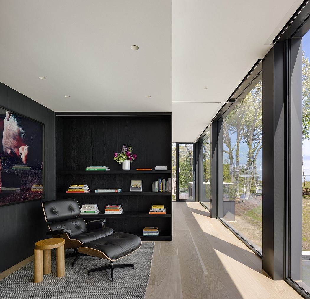 Contemporary living space with modern furnishings, expansive windows, and black shelving.