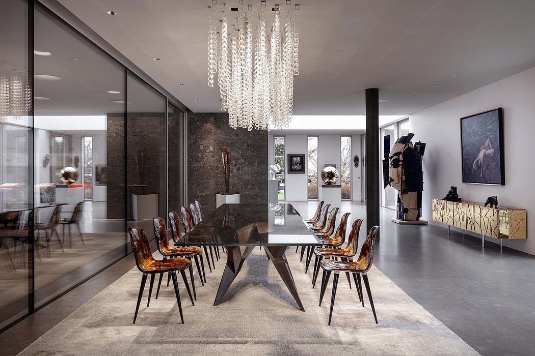 Luxurious dining area with a large glass table, intricate chandelier, and modern decor.