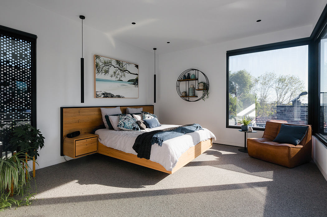 Spacious modern bedroom with wood bed frame, round wall mirror, and large windows.
