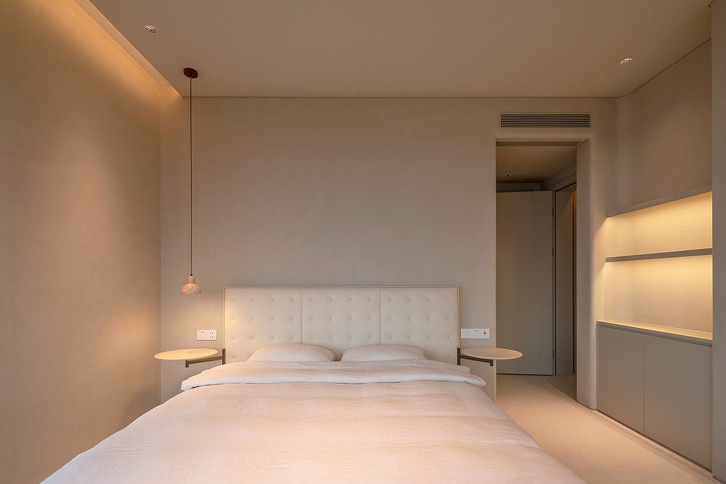 Minimalist bedroom design with tufted headboard, pendant lighting, and built-in shelving.