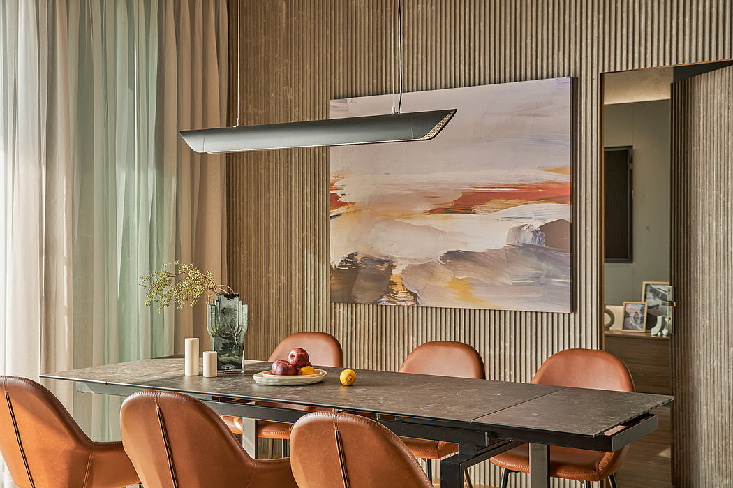 Warm-toned dining room with sleek lighting fixture, textured wall paneling, and modern furnishings.