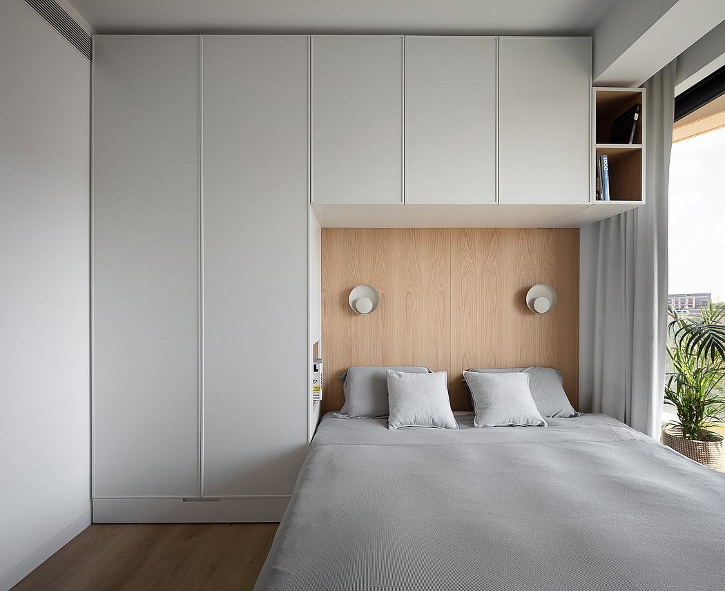 A minimalist bedroom with built-in wooden headboard and gray storage cabinets.