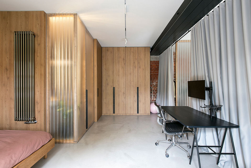 Modern studio with wood paneling, industrial radiator, and desk workspace.