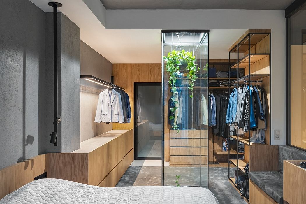 Sleek, minimalist bedroom with glass wall closet, wooden accents, and indoor plants.