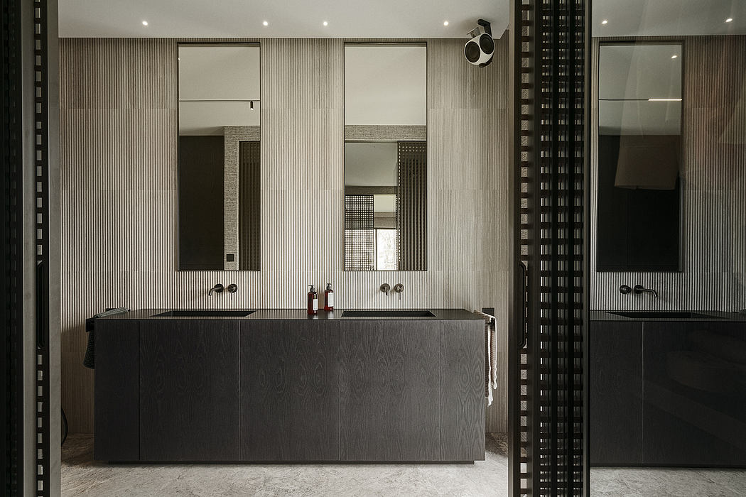Sleek, modern bathroom with black cabinetry, tiled walls, and recessed lighting.