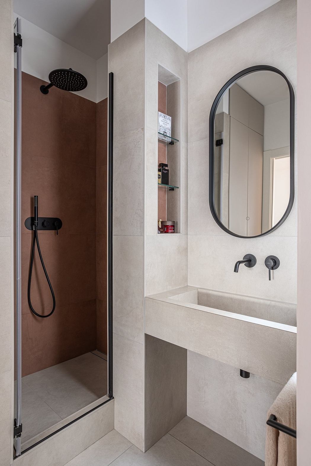 Sleek, modern bathroom with minimalist design, black hardware, and recessed shelving.