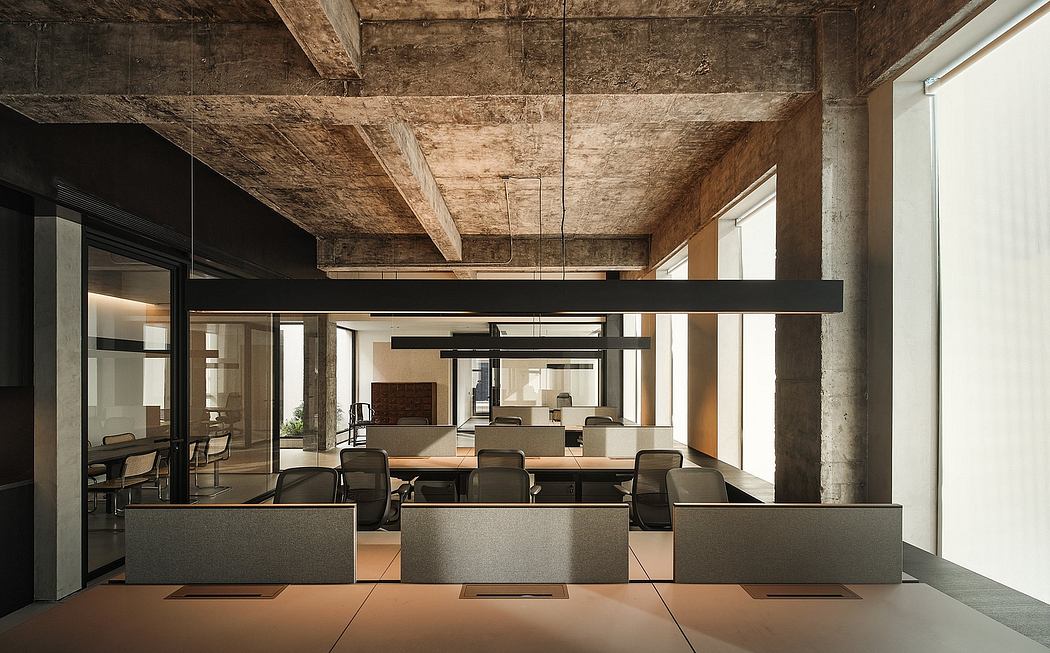 Modern industrial-style office with exposed wooden beams, glass partitions, and minimalist furnishings.