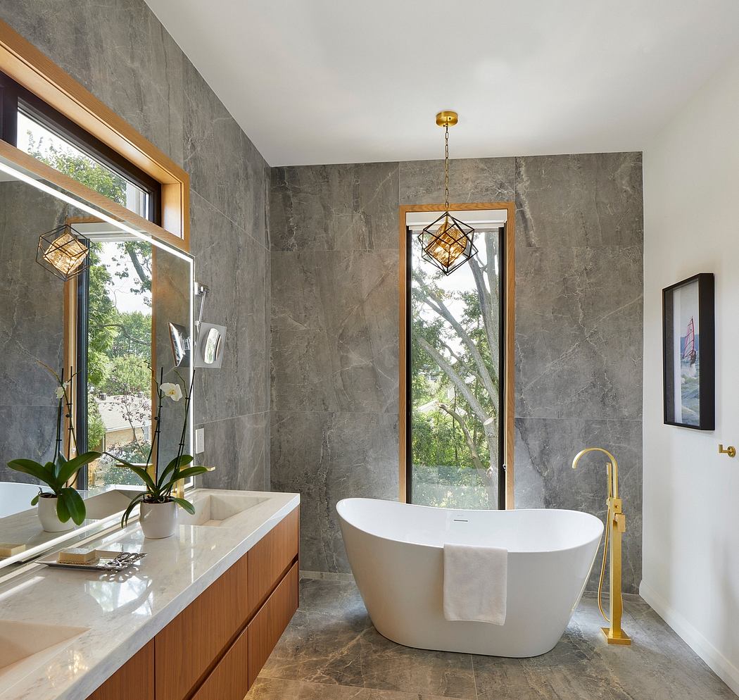 Elegant bathroom with marble walls, freestanding tub, vanity, and pendant lighting.