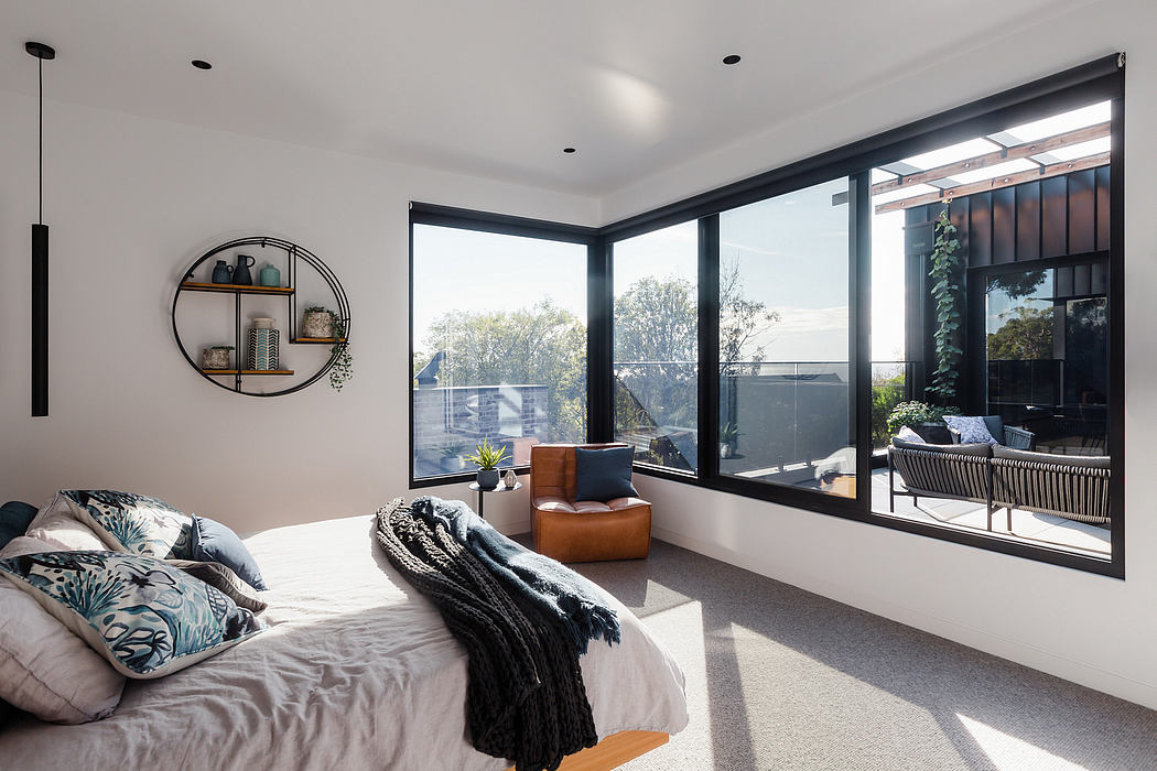 Large windows provide a panoramic view in this modern, cozy bedroom with stylish decor.