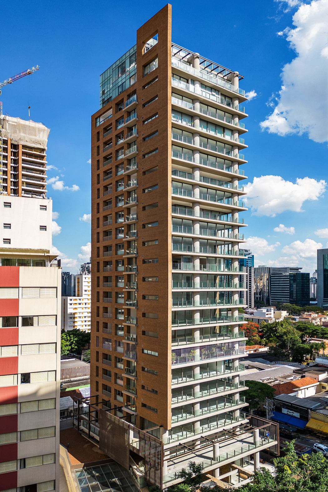 A modern, high-rise apartment complex with distinctive brick facade and glass balconies.