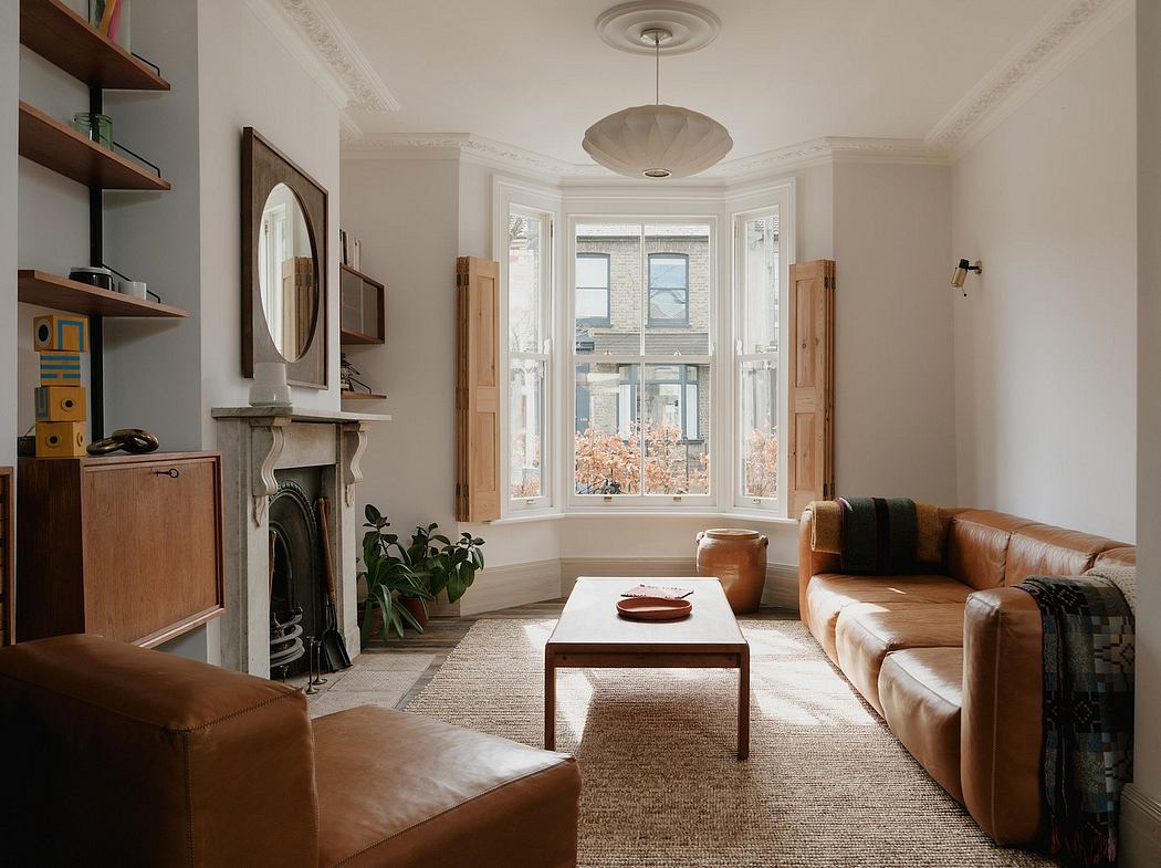 Cozy living room with tall windows, wooden shelves, and mid-century modern furnishings.