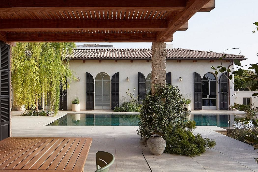 Elegant Mediterranean-style villa with a courtyard, pool, and lush greenery.