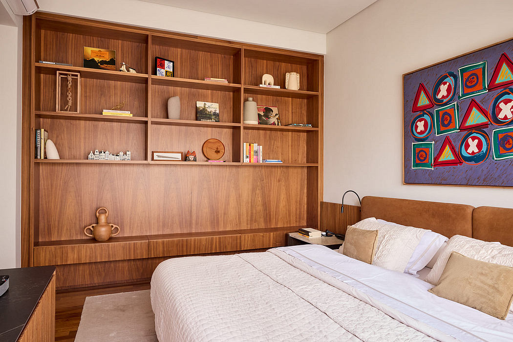 Cozy bedroom with warm-toned wood shelving, colorful abstract artwork, and minimalist furnishings.