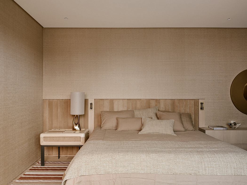 A spacious, modern bedroom with a neutral color palette and minimal decor. Elegant lighting and bedding.