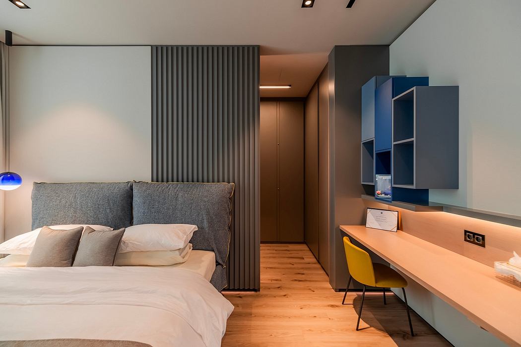 Sleek, modern bedroom with gray upholstered wall, wood floors, and built-in storage.