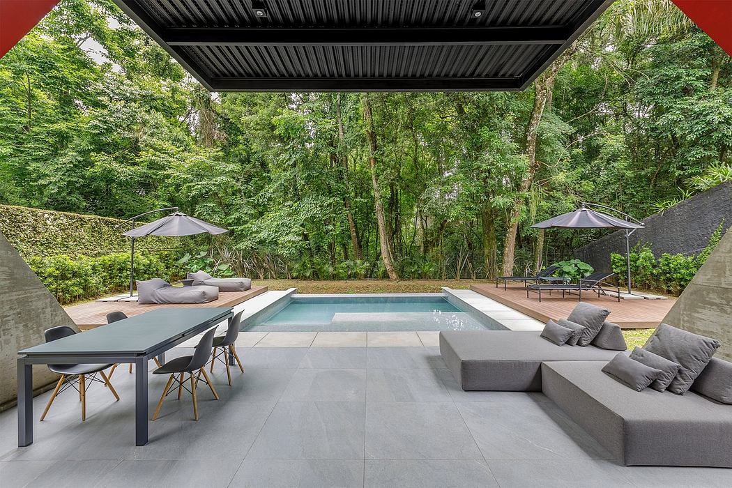 Luxurious outdoor living space with modern pool, lounge, and dining areas surrounded by lush greenery.