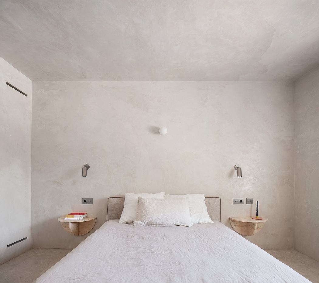 Minimal, serene bedroom design with recessed lighting, floating nightstands, and textured walls.