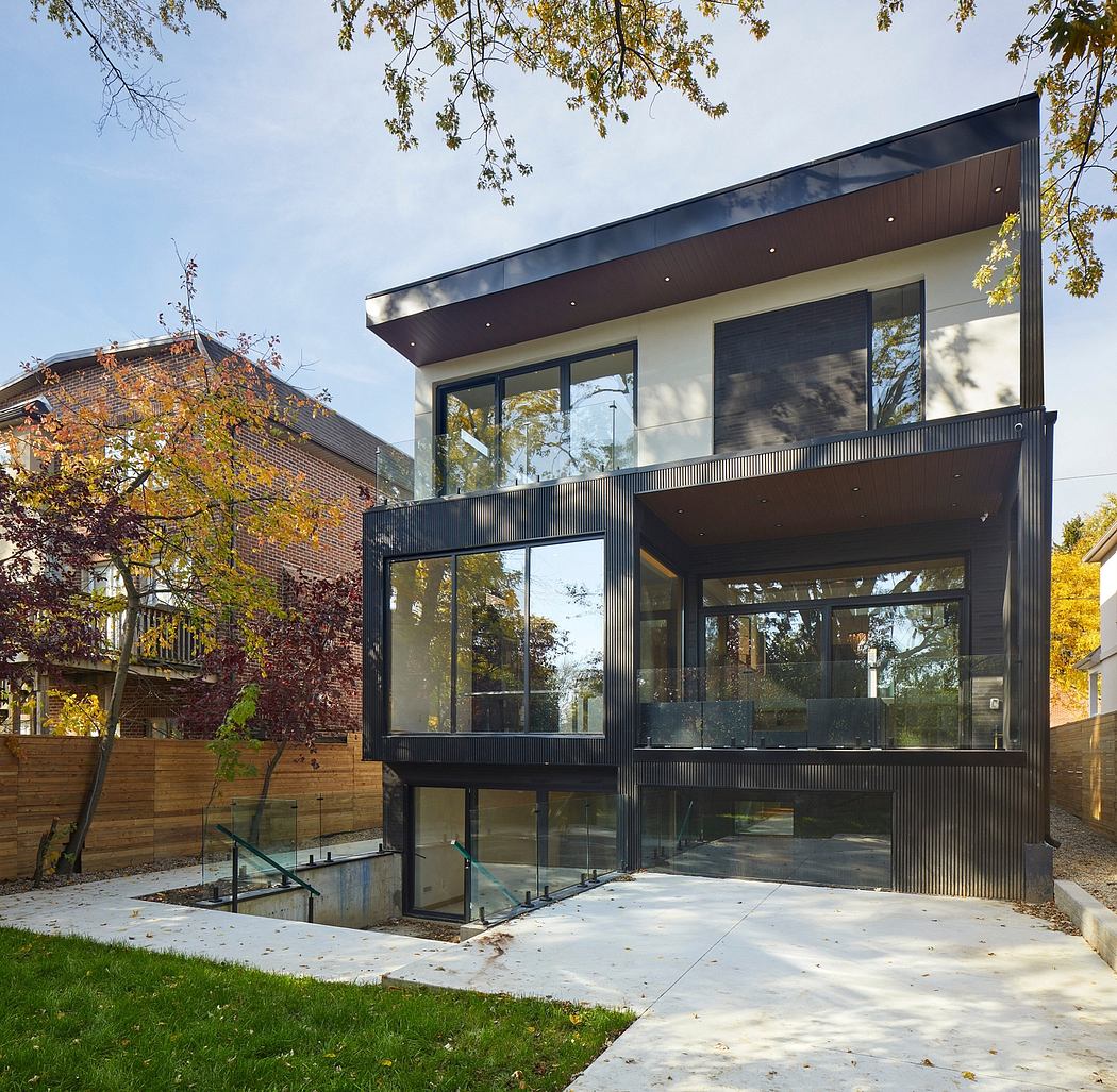 Modern two-story home with sleek black exterior, large windows, and minimalist design.