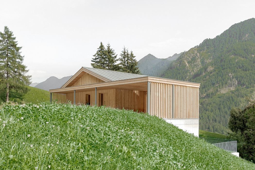 A modern wooden cabin nestled in a lush green meadow, surrounded by towering mountains.
