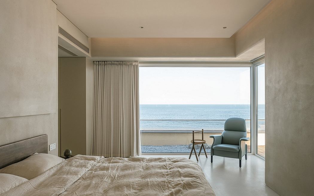 Spacious bedroom with floor-to-ceiling windows overlooking the serene ocean view.