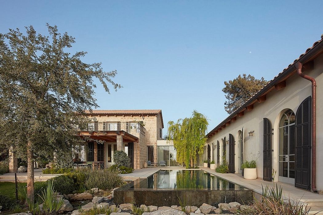 Elegant Spanish-style villa with a serene reflecting pool, lush landscaping, and arched windows.