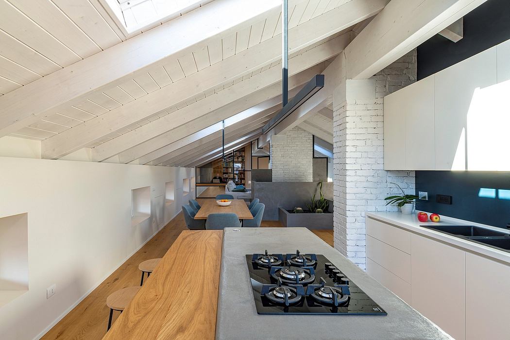 Spacious attic interior with wood-beamed ceiling, modern kitchen, and cozy dining area.