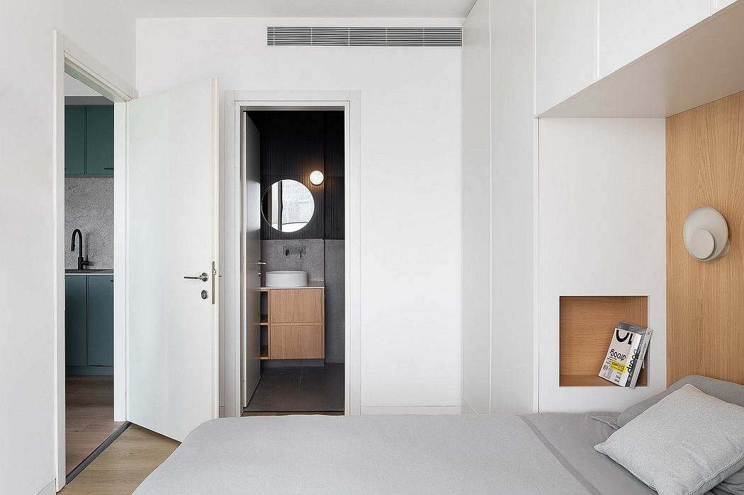 Minimalist bedroom design with circular mirror, recessed storage, and wood accents.