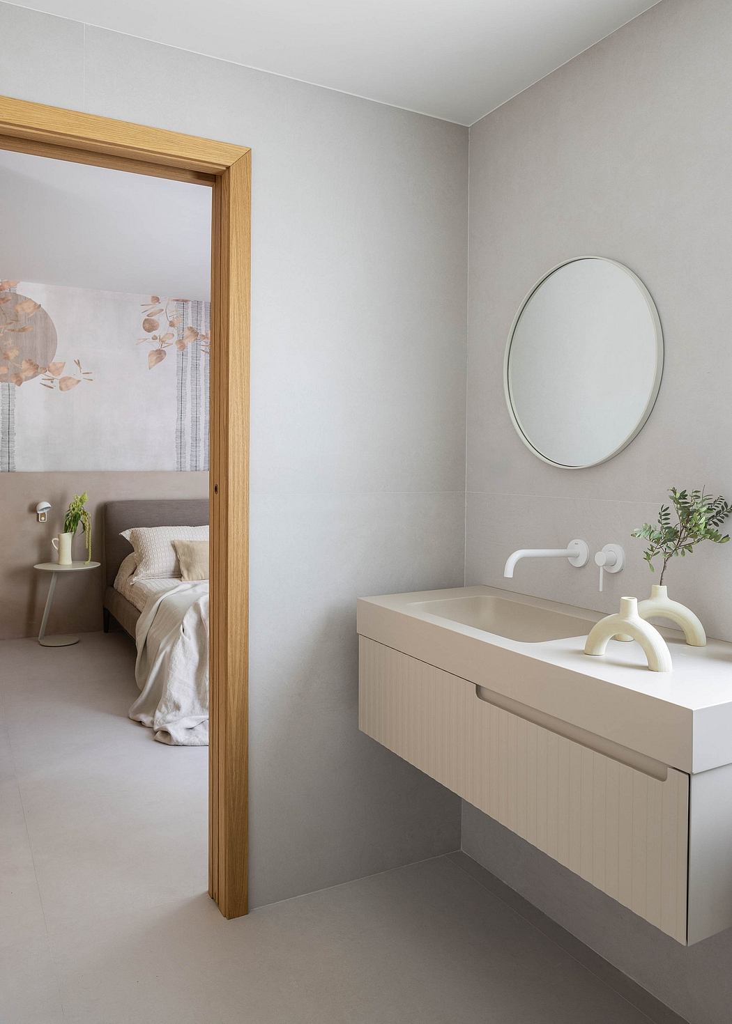 Minimalist bathroom design with neutral tones, floating vanity, and round mirror.