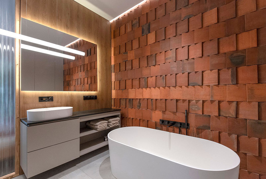 Sleek, modern bathroom with white tub, vanity, and textured brick wall.