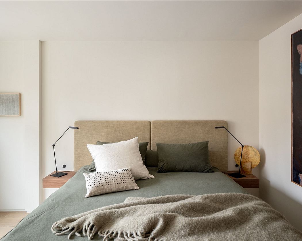 Minimalist bedroom with neutral tones, textural bedding, and modern lighting.