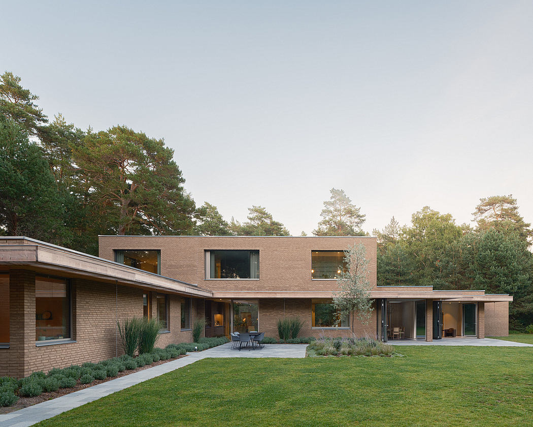 Striking modern architecture with brick facade, expansive windows, and landscaped grounds.