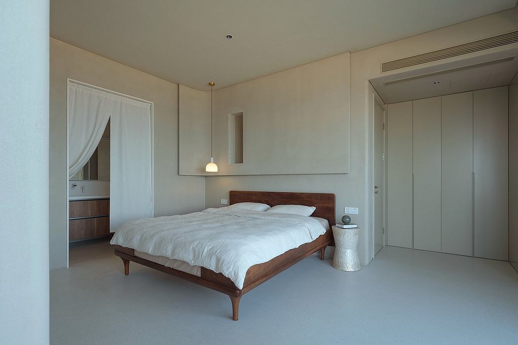 Spacious, minimalist bedroom with wood-framed bed and neutral-toned decor.