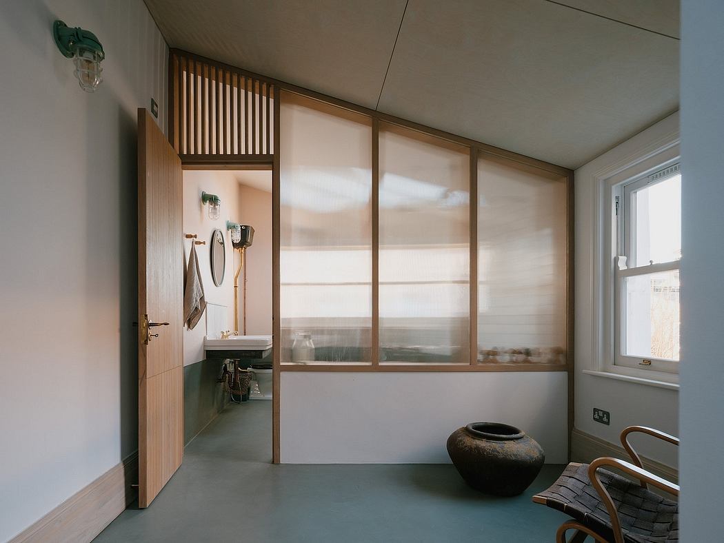 A minimalist room with wooden slat walls, frosted glass panel, and a stone pottery piece.
