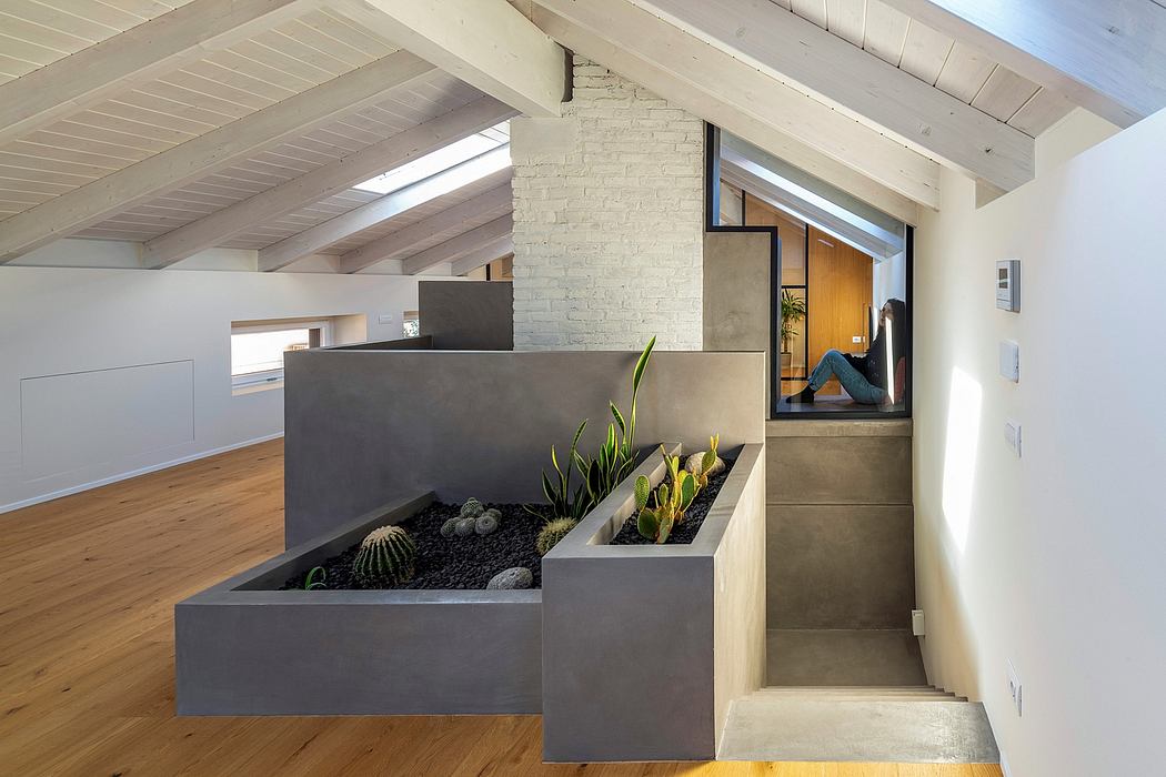 Airy loft with exposed wood beams, recessed planter boxes, and concrete staircase.