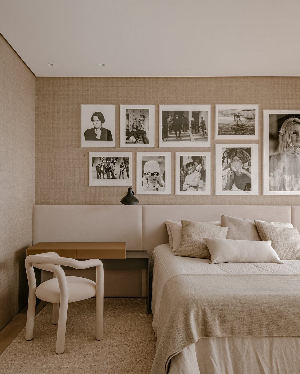 Cozy, modern bedroom with a gallery wall of black-and-white photographs.
