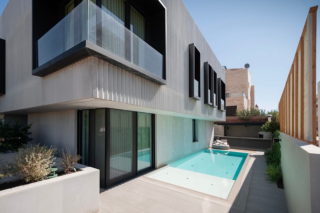 A modern apartment building with a sleek exterior and a small private pool, surrounded by a landscaped courtyard.