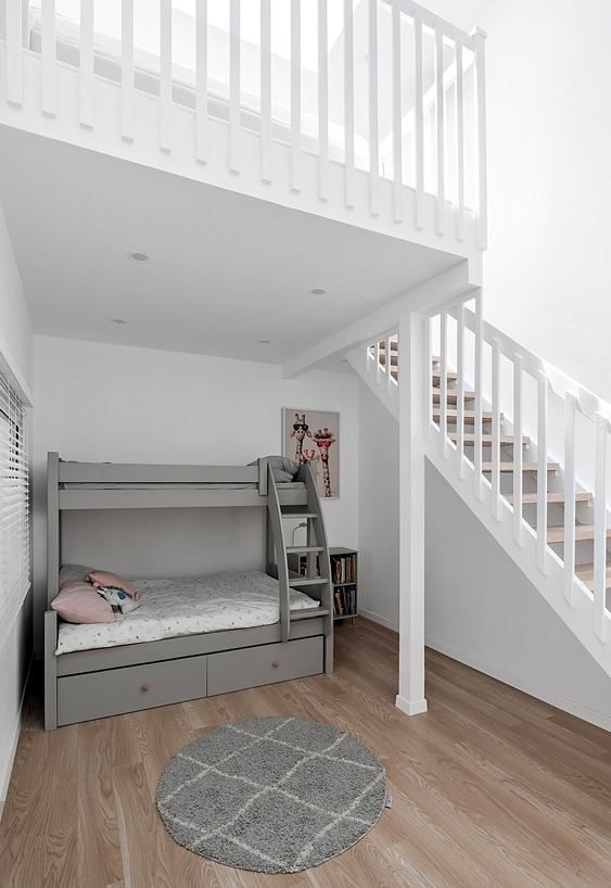 Minimalist bedroom design with bunk bed, floating stairs, and hardwood floors.